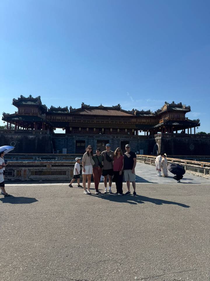 Group of travelers standing in front of the ornate main gate of the Imperial City in Hue.