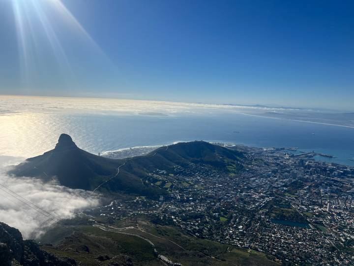 Sweeping aerial panorama of Cape Town with Lion's Head rising above the coastal city and shimmering ocean