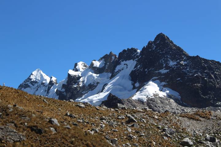 Sharp snow-covered peaks of the Salkantay mountain range against deep blue sky.