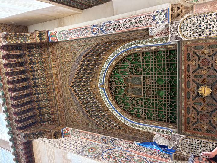 Richly decorated Islamic archway with intricate wood and tile work in Fes.