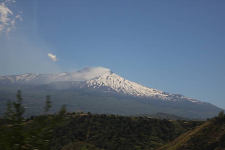 Distant snow-capped Mount Etna seen across hazy landscape