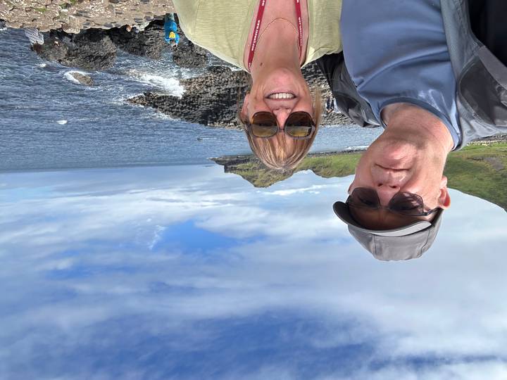 Selfie of a couple with the rocky basalt columns and ocean at Giant's Causeway behind