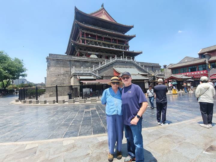 Older couple posing in front of Xi'an Drum Tower on a sunny day