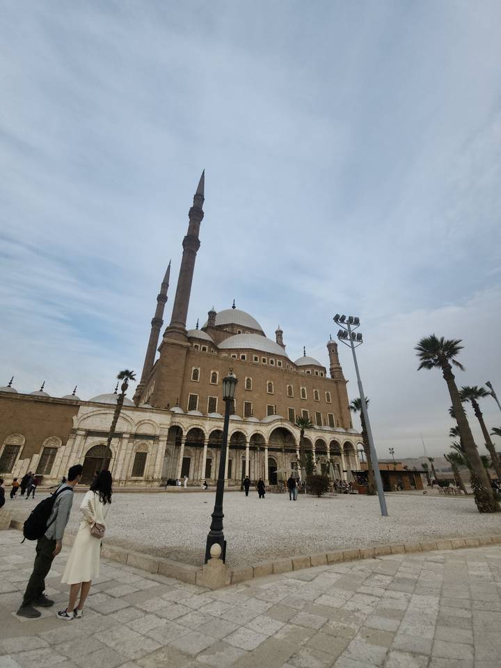 Mosque of Muhammad Ali with towering minarets under a pale sky in Cairo