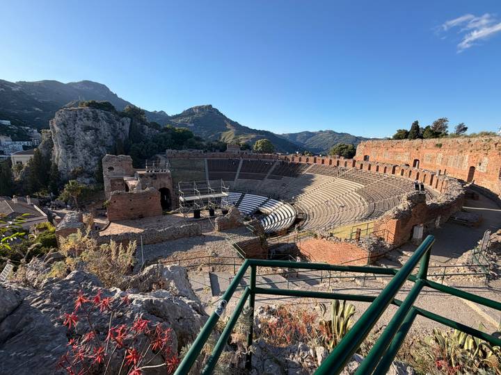 Sweeping view of the ancient Greco-Roman theatre in Taormina with rugged cliffs and mountains behind