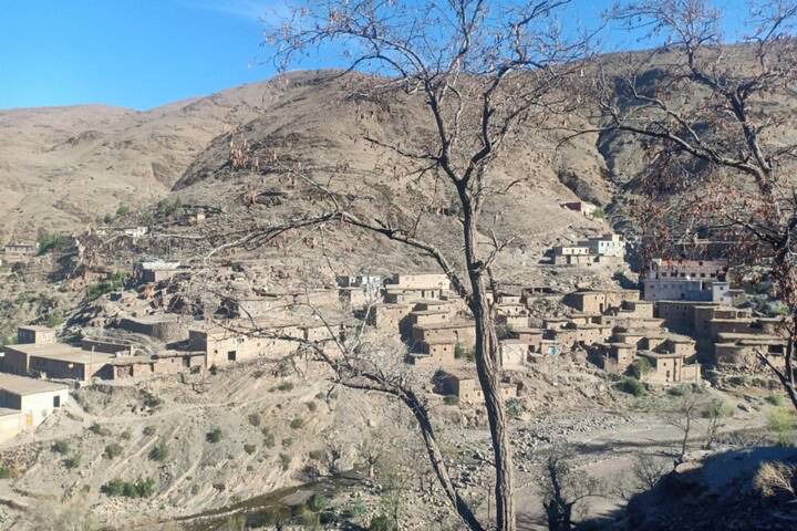 Remote Berber mountain village with stone houses scattered across arid hillsides.