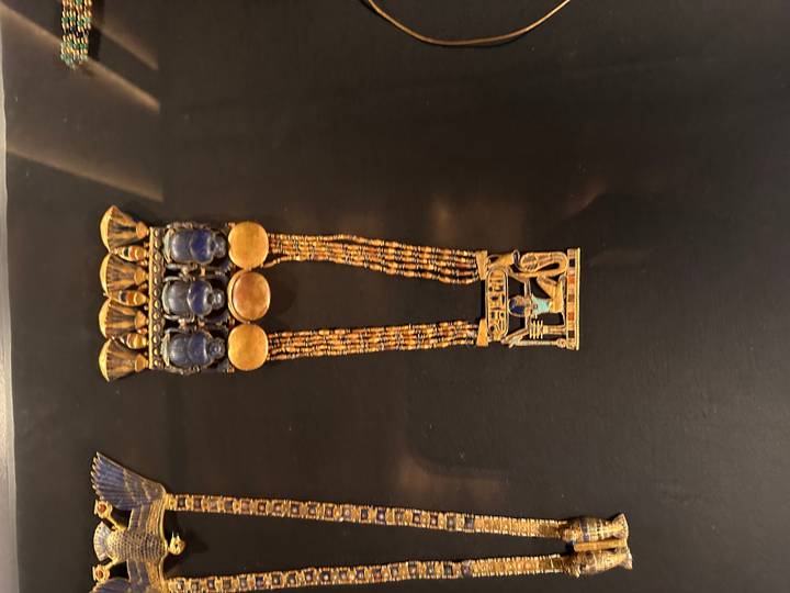 Intricate gold and lapis necklace of ancient Egypt displayed on black background