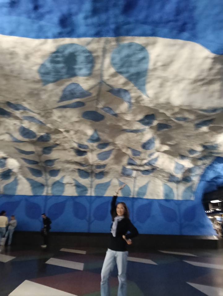 Blurry image of blue-and-white patterned cave ceiling with person pointing upward.