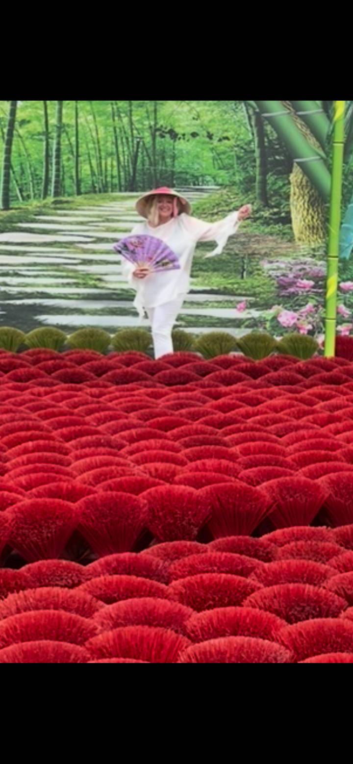Rows of bright red incense sticks laid out in dense patterns for drying.