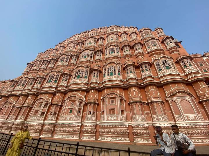 Grand pink sandstone facade of Hawa Mahal with intricate latticed windows stretching skyward