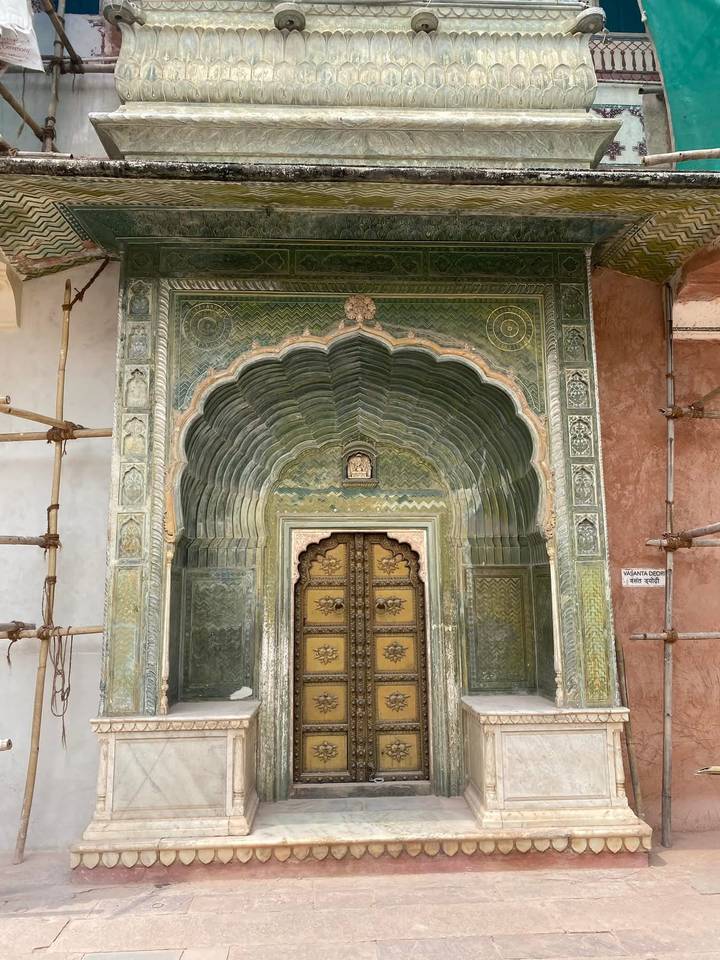 An ornate green arched doorway with gold details at Jaipur’s City Palace complex.
