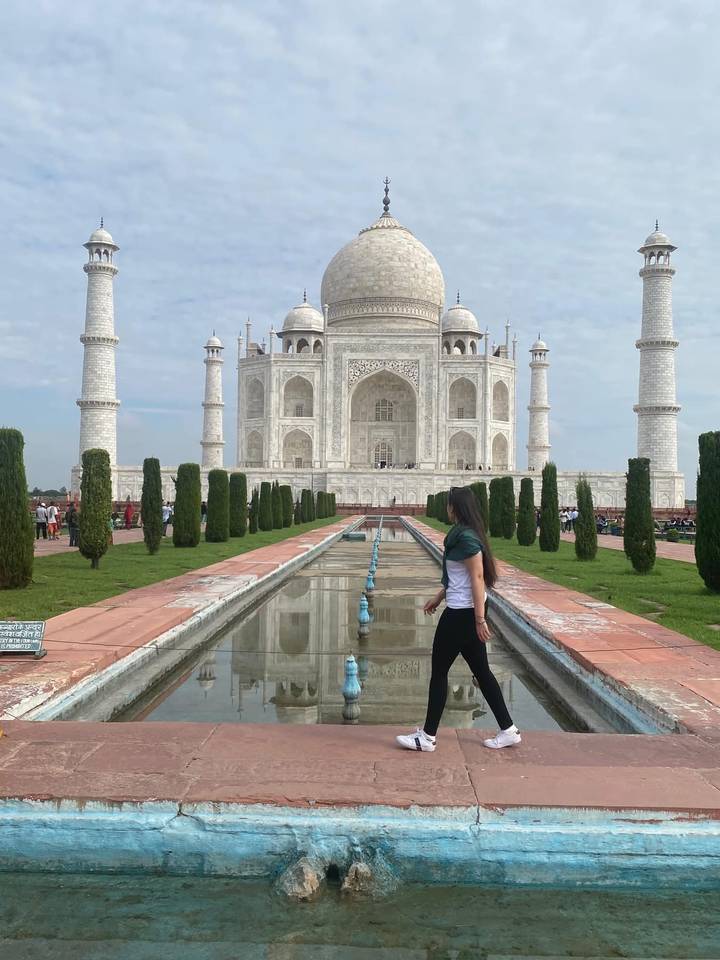 A visitor walks beside the long reflecting pool leading to the iconic white Taj Mahal.