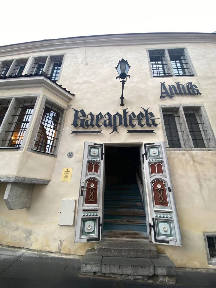 Historic pharmacy facade with gothic lettering and ornate double doors.