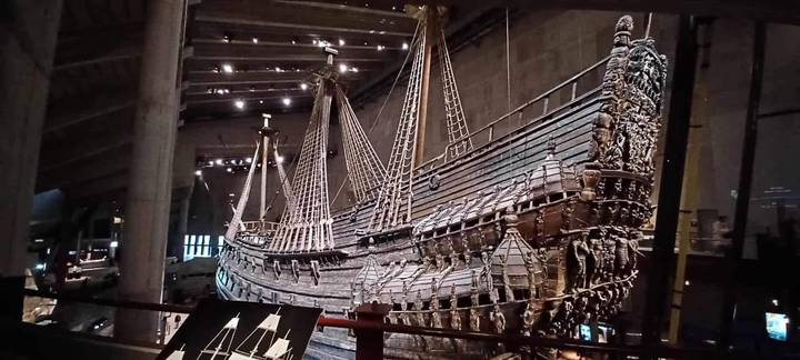 Historic 17th-century wooden warship displayed in a dim museum hall.