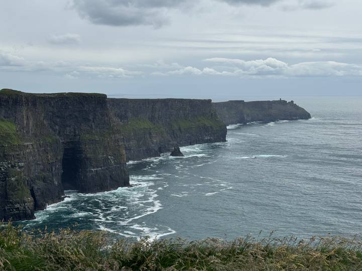 Iconic cliffs rising vertically from the Atlantic Ocean with waves below