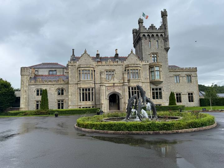Grand stone castle hotel with central fountain on a rainy day