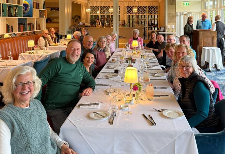Large tour group enjoying a meal together at a long restaurant table