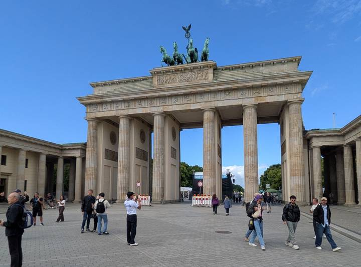 Brandenburg Gate in Berlin with tourists milling around on sunny day