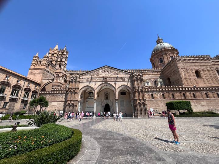 Wide view of Palermo Cathedral’s ornate exterior with tourists in the forecourt.