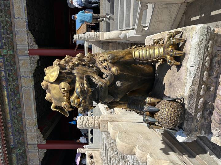 Bronze guardian lion statue guarding a marble staircase in the Forbidden City.