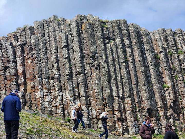 Tourists examining the towering hexagonal basalt columns of the Giant’s Causeway.