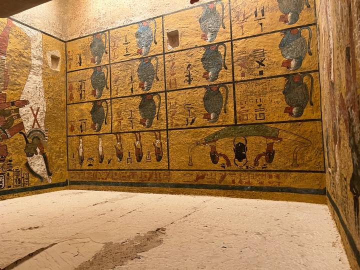 Colorful wall paintings depicting baboons and Egyptian deities inside a pharaonic tomb.