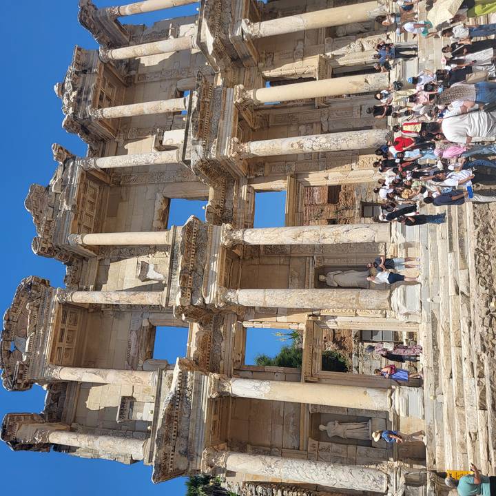 Crowds gather before the grand marble facade of the Library of Celsus in Ephesus.