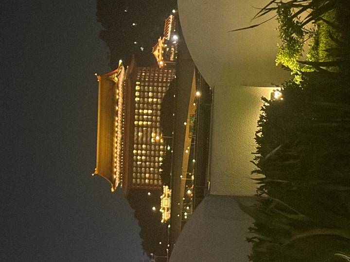 A large traditional Chinese-style hotel dramatically illuminated at night.
