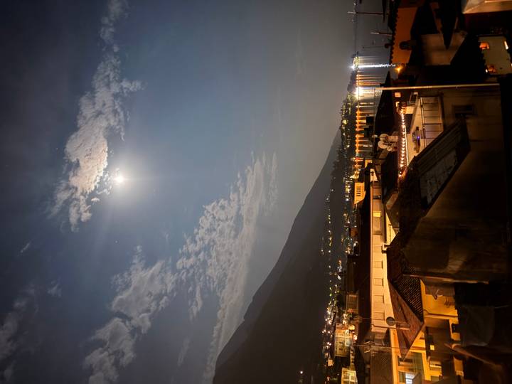 Moonlit view over lakeside town with reflections on calm water
