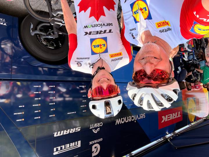Cyclists selfie in front of professional team bus at event village