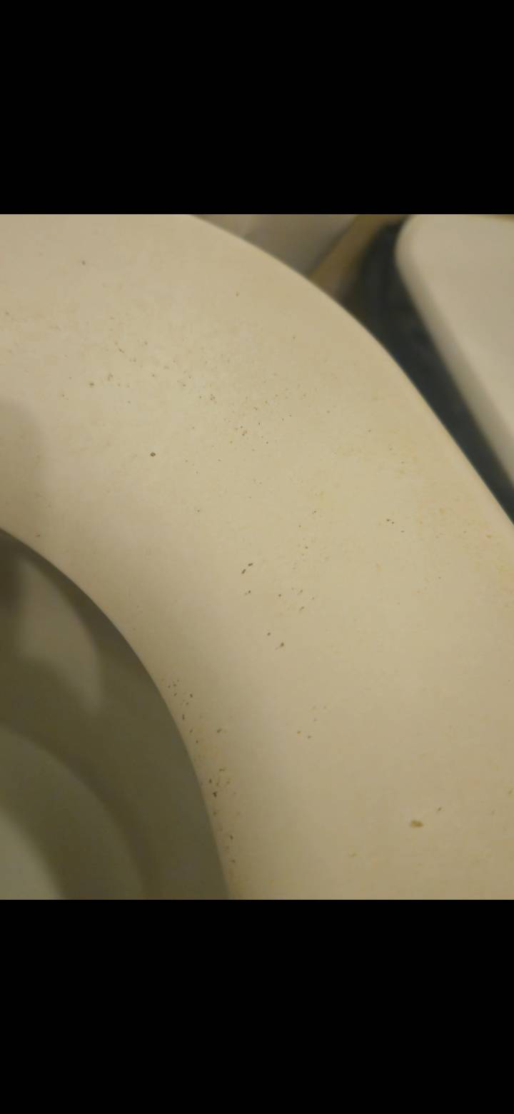 Extremely close shot of a stained off-white surface with little detail.
