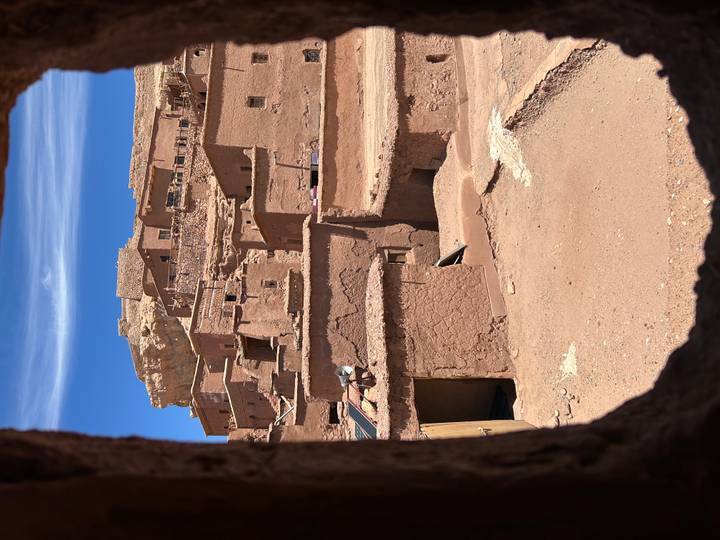 View through a mud-brick window onto the terracotta kasbahs of Ait Benhaddou