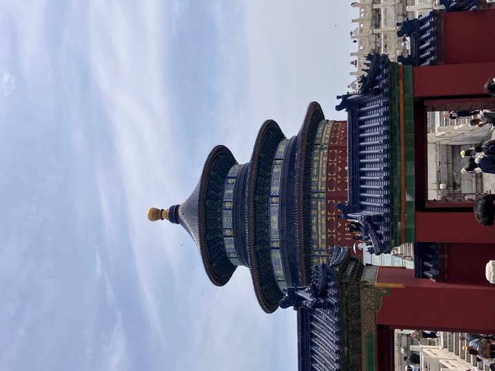 The circular Hall of Prayer at Beijing’s Temple of Heaven rises against a wispy sky as visitors mill below.