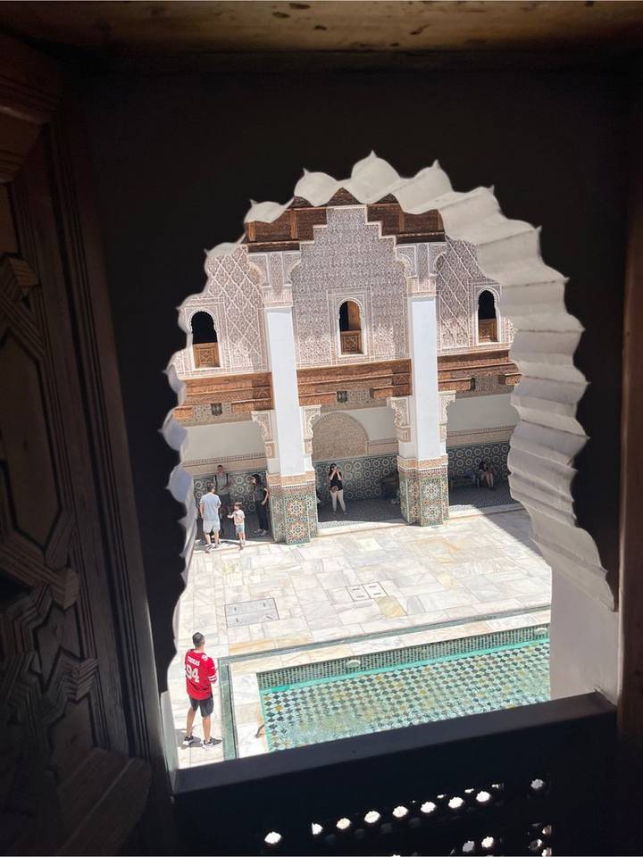 Courtyard of Medersa Ben Youssef viewed through scalloped window frame