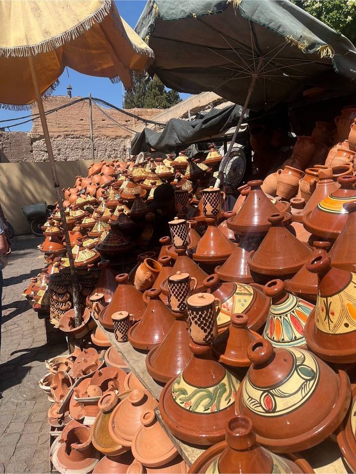 Street market stall stacked with rows of clay tagine pots