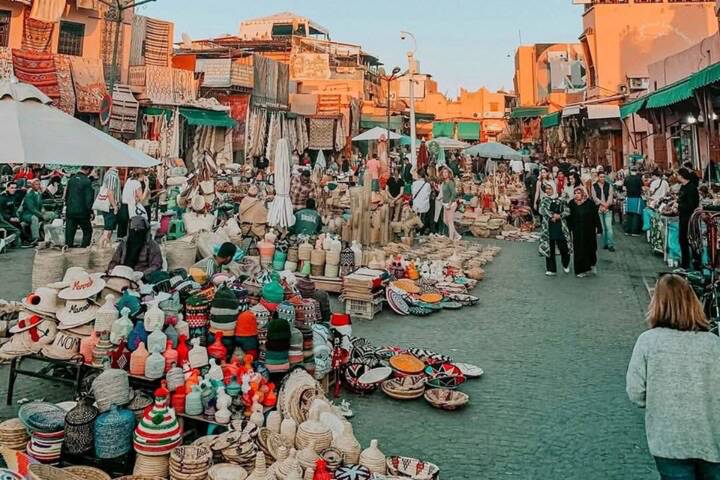Bustling open-air market square with handicrafts and shoppers at dusk