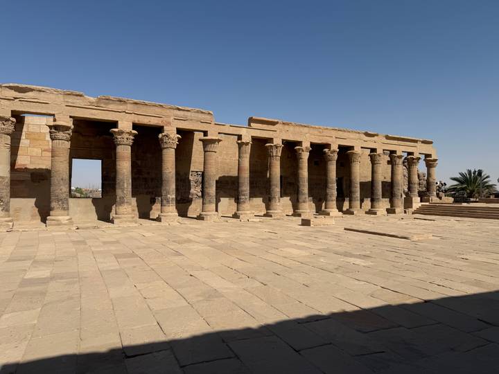 Stone colonnaded hall of an ancient Egyptian temple under clear sky