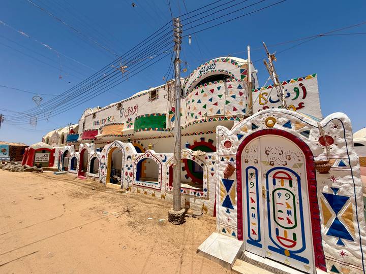 Colorfully painted Nubian village buildings with geometric murals under bright blue sky
