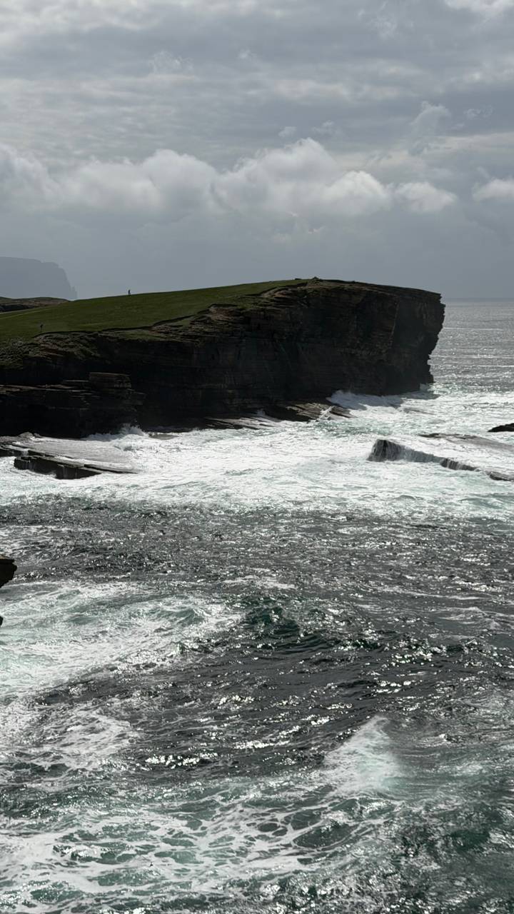 Powerful waves crashing against dark coastal cliffs sending white spray into the air