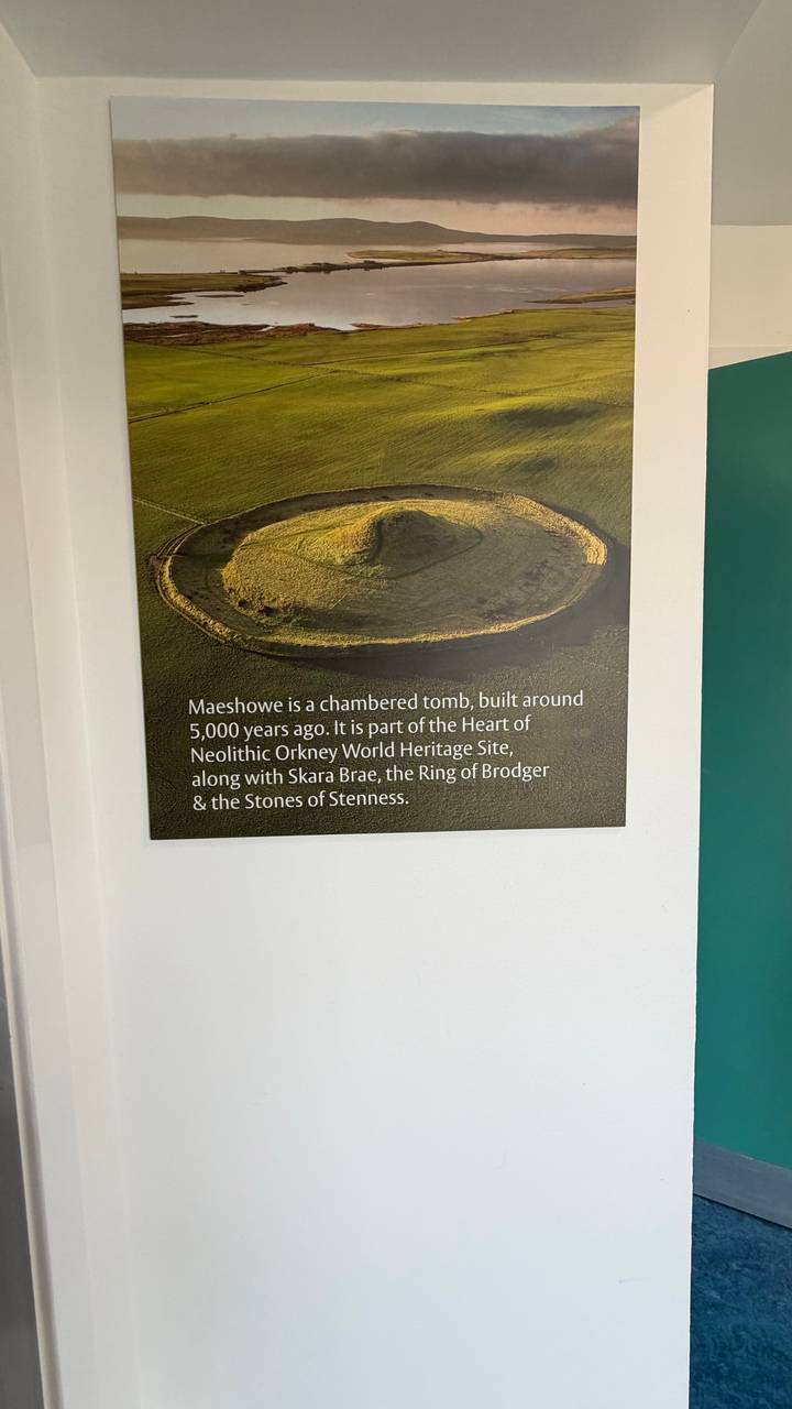 Information panel featuring an aerial photo of Maeshowe chambered tomb with descriptive text