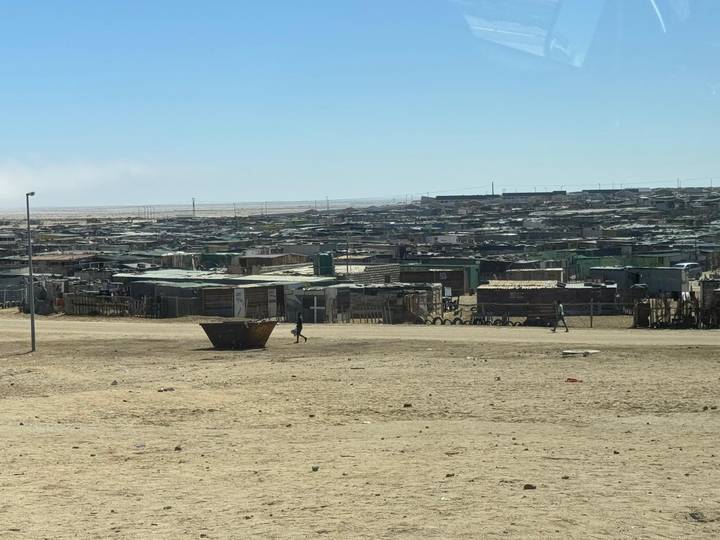 Expansive view of a dusty shanty settlement on barren desert outskirts