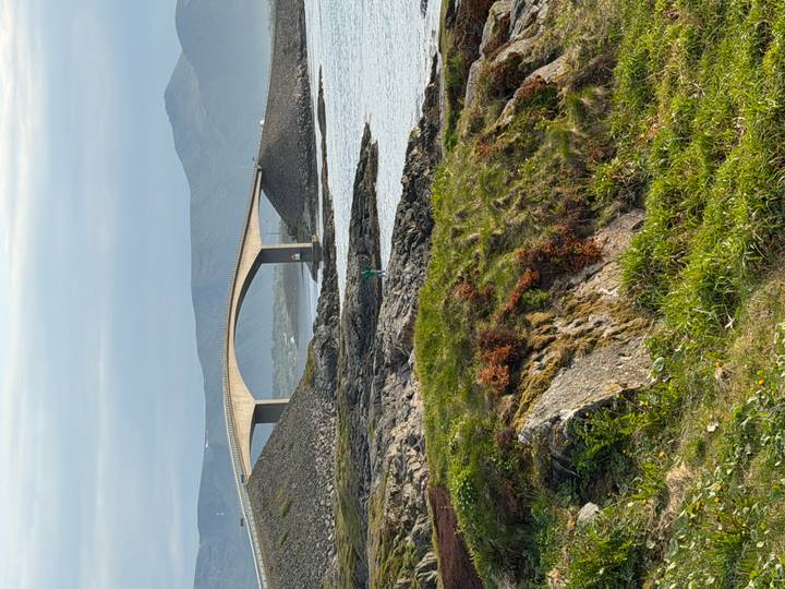 Curving concrete bridge of the Atlantic Ocean Road spans rocky islets amid calm coastal waters