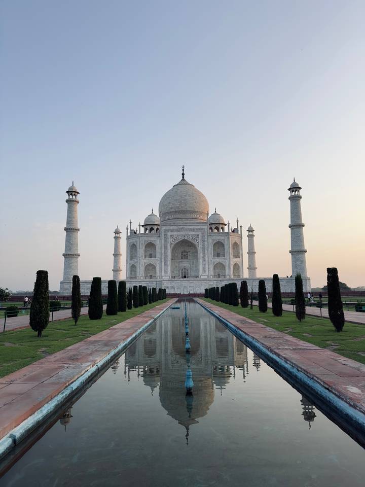 Classic frontal view of the Taj Mahal reflected in the long water channel at dawn