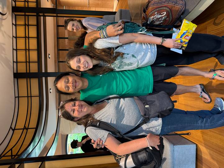 A friendly farewell photo of travellers with a local guide inside a reception area.