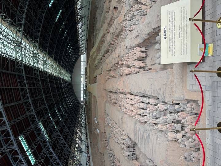Wide interior of Pit 1 displaying rows of the Terracotta Warriors beneath a vast steel roof.