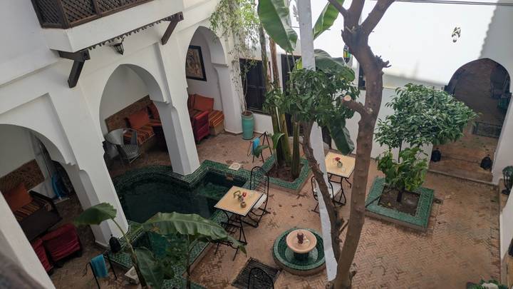 Charming riad courtyard with plunge pool, tiled floors, leafy trees and cozy seating