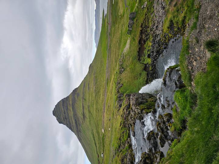 Iconic Kirkjufell mountain with cascading stream and small waterfall in foreground