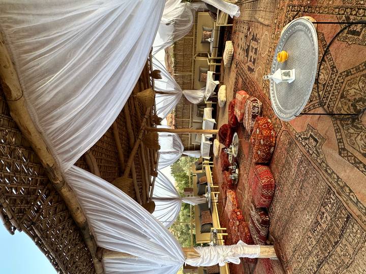 Cozy Moroccan lounge under draped white fabric with patterned cushions and low tables