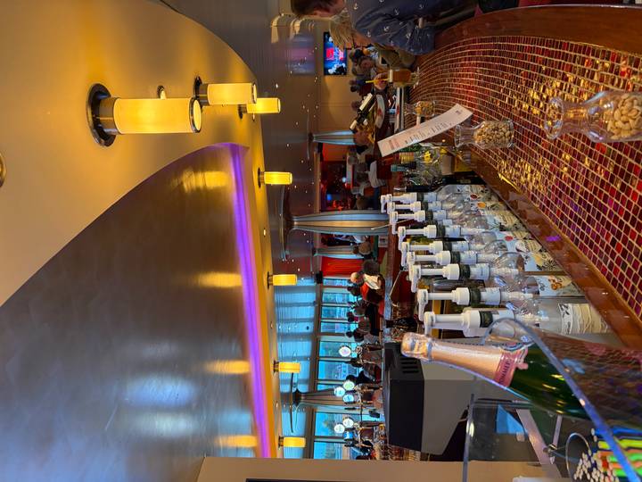Well-stocked bar on a cruise ship with bottles, snacks and warm ambient lighting