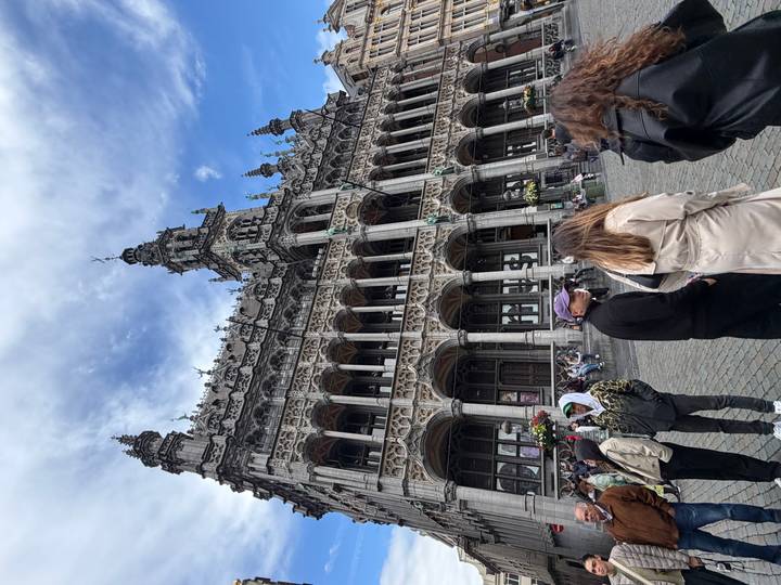 The elaborate neo-Gothic façade of Brussels’ Town Hall towering over visitors in the cobblestone square.